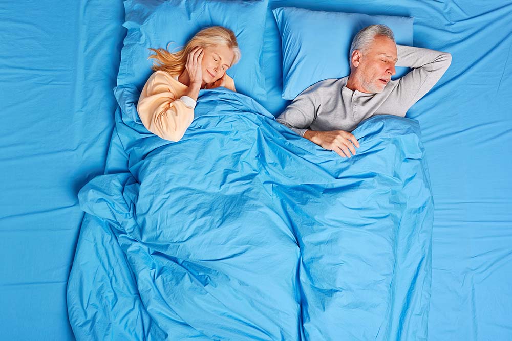 Ζευγάρι στο κρεβάτι όπου η γυναίκα δεν μπορεί να κοιμηθεί λόγω του ροχαλητού του άντρα